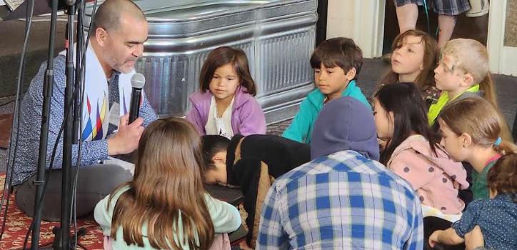 A leader teaching children gathered on a rug at Access Covenant Church